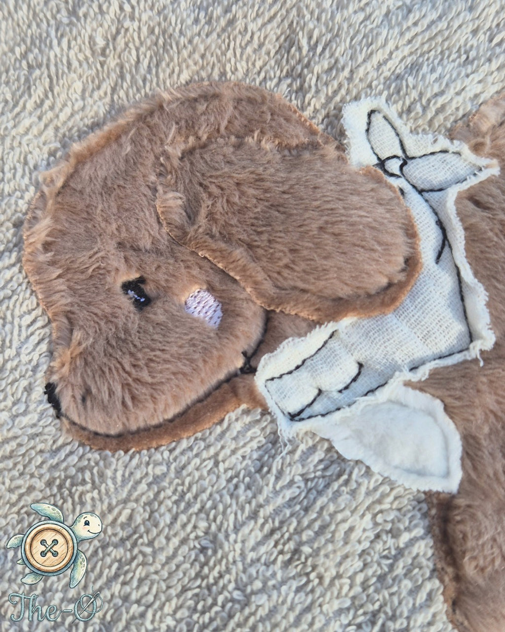 The-O Dackel Set bestehend aus einem beigen Frottee-Handtuch mit flauschiger Dackel-Applikation und Stickerei
