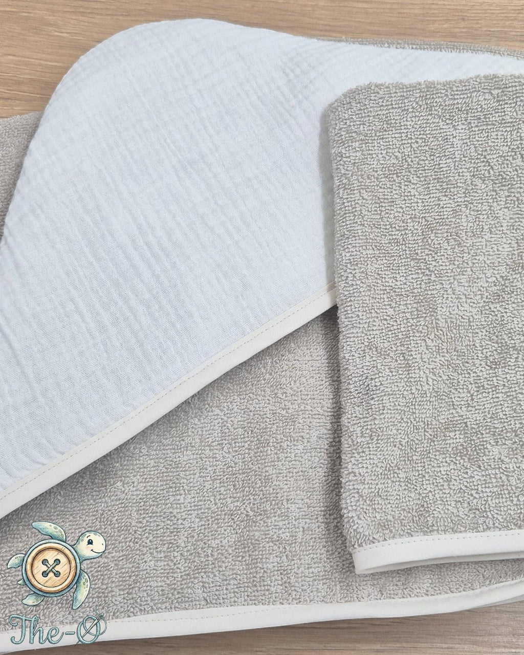 The-O Dackel Set aus beigem, weichem Frottee-Handtuch und Waschlappen mit dezenter Einfassung für Babys